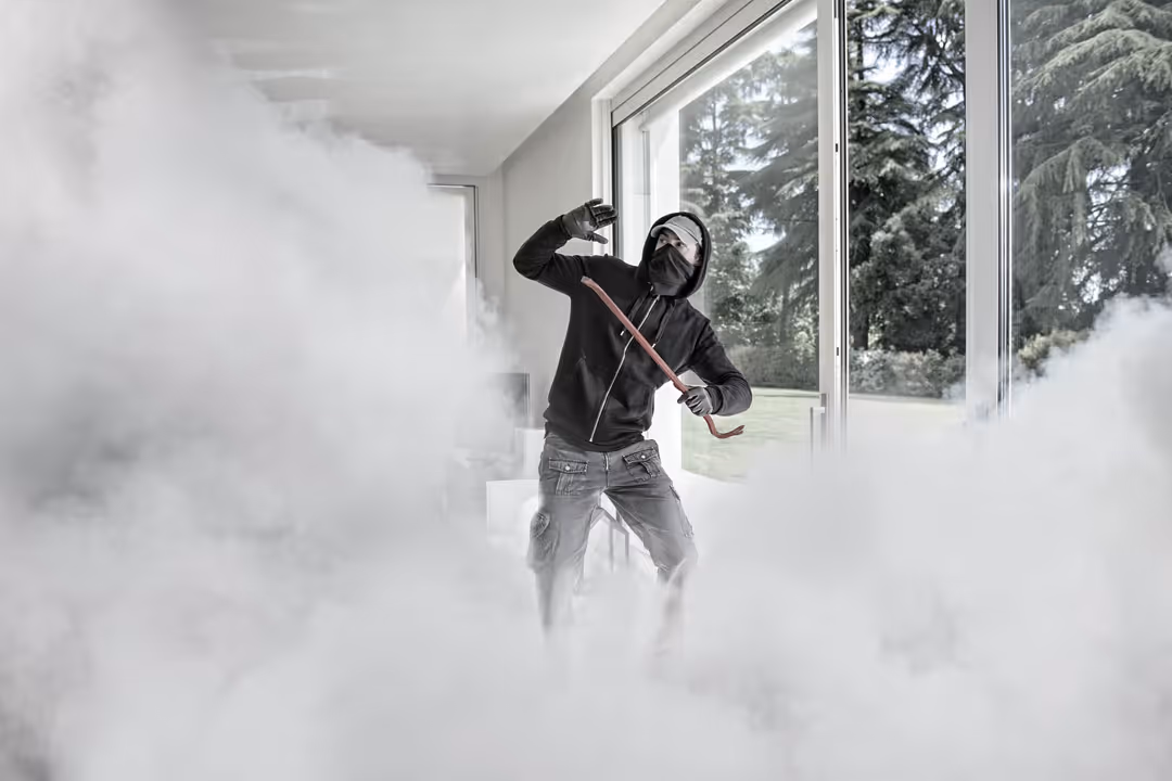 Person in hoodie amidst smoke indoors
