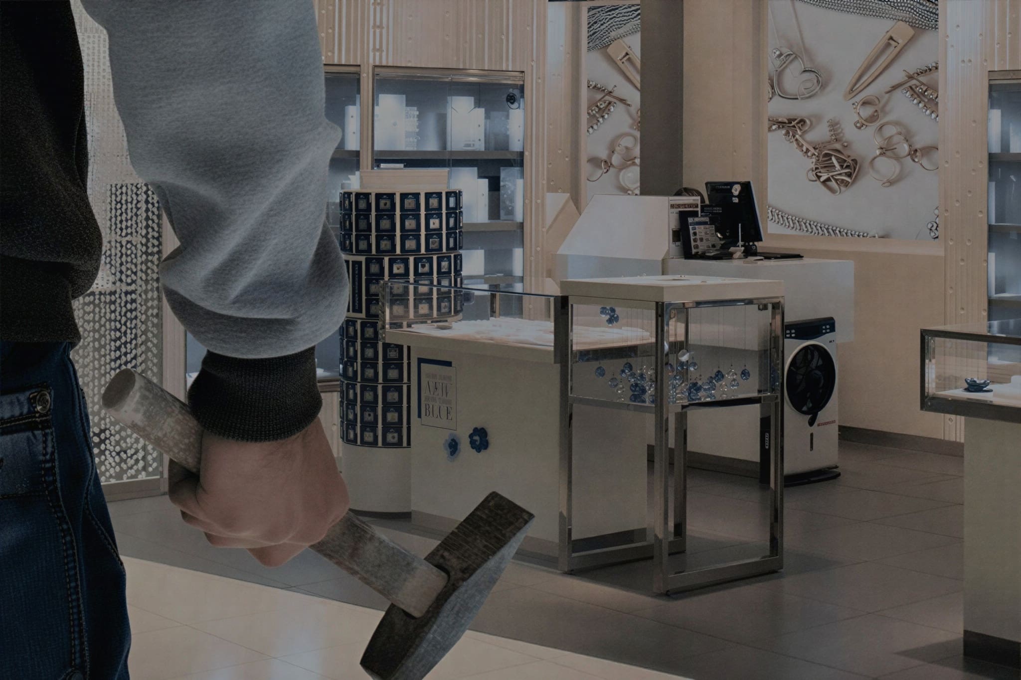 Person holding hammer inside jewelry store