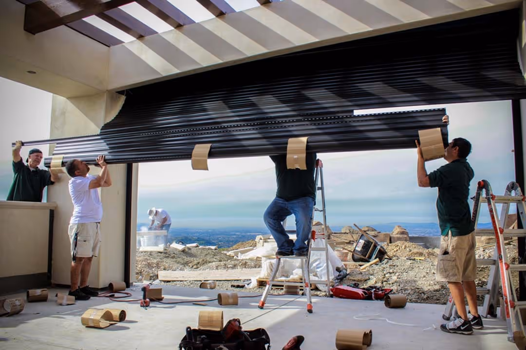 Workers assembling garage door system