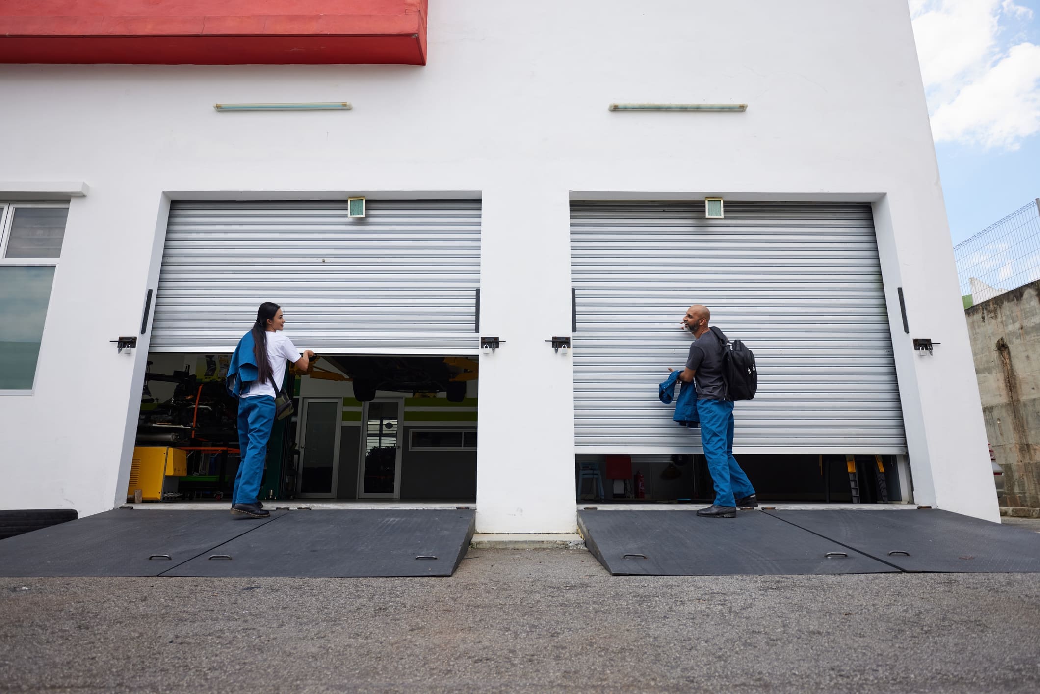 Two people opening garage shutters in Inland Empire.