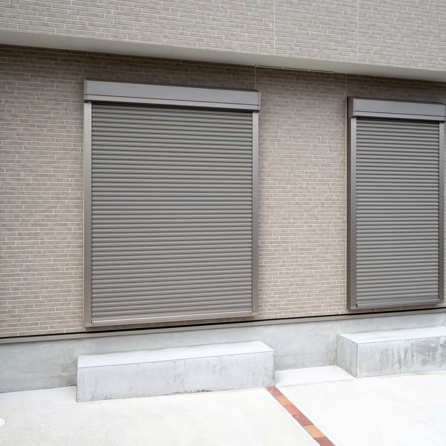 Two closed metal shutters on building exterior.