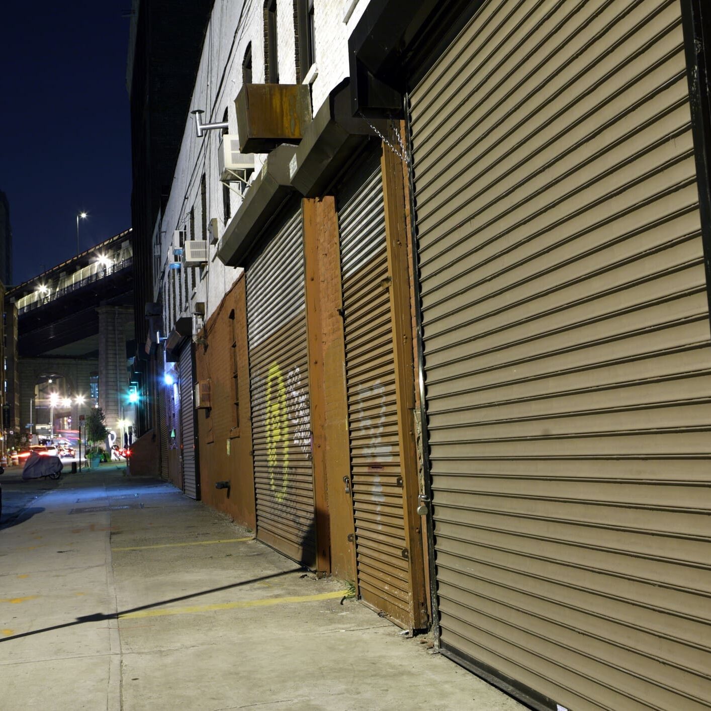 City street at night with closed storefronts.